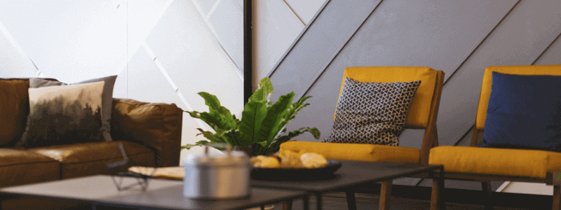 salon minimalista con sofa rinconera en cuero marron y mesa de centro en marmol