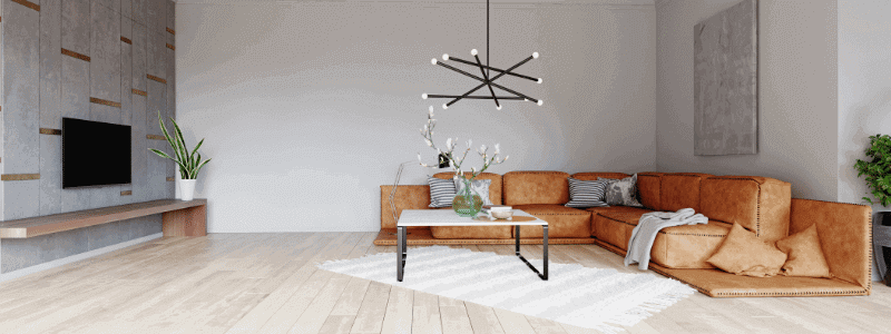 salon minimalista con sofa rinconera en cuero marron y mesa de centro en marmol